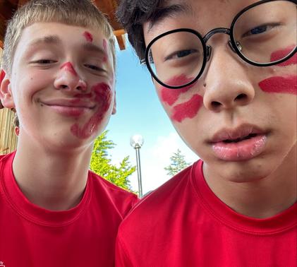 Two students smiling covered in red paint