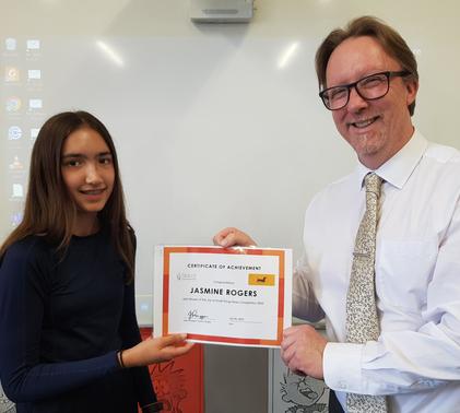 Jasmine receiving her certificate for winning a mini essay competition.