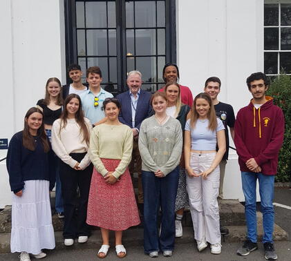 Students smiling at receiving their a-level results with Sidcot Head Iain Kilpatrick