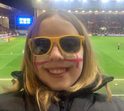Young girl taking selfie at England football match