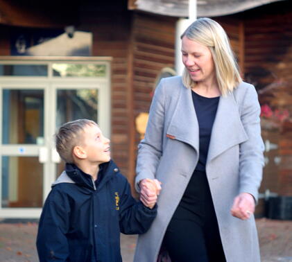 Parent walking with their child outside a private school
