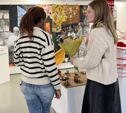 Two students looking at IB Art Exhibition