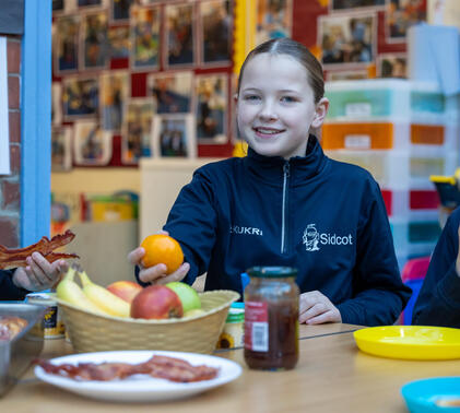 Sidcot Junior School pupil picking up fruit