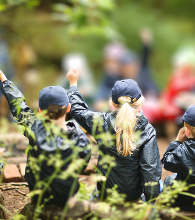 A class outdoors in forest school.