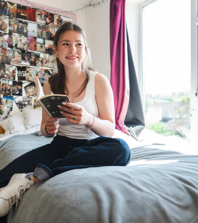 girl sat on bed in boarding house