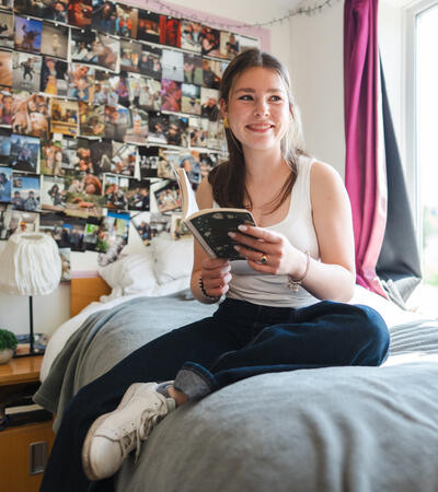 a girl sat on a bed reading
