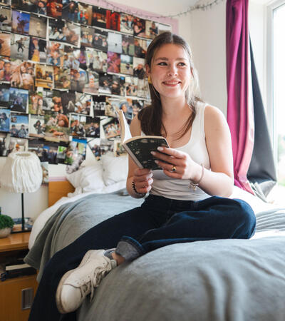 Sidcot student sitting on bed in boarding house