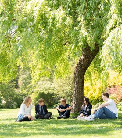 Sidcot students sitting in a group in beautiful countryside setting