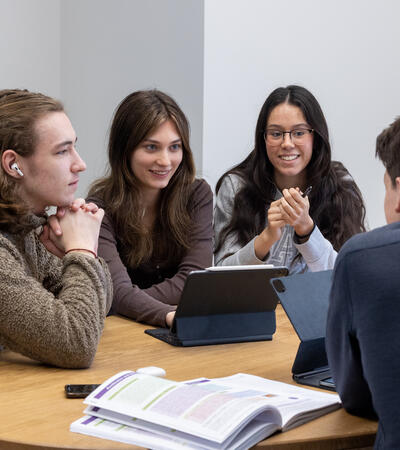group of students huddled around table learning together