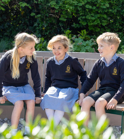 Three Sidcot Junior School Students sitting in the Peace Garden