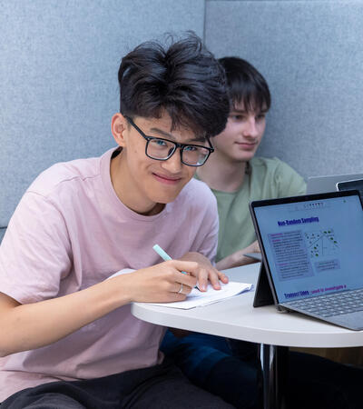 Sidcot Sixth Form student smiling at the camera while studying