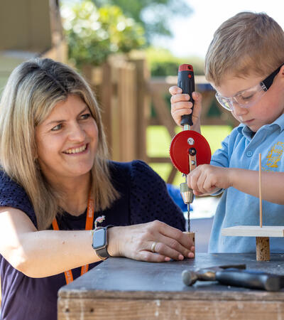 Lucy Beardsley, Head of Early Years at Sidcot School, helping a child in Pre-School