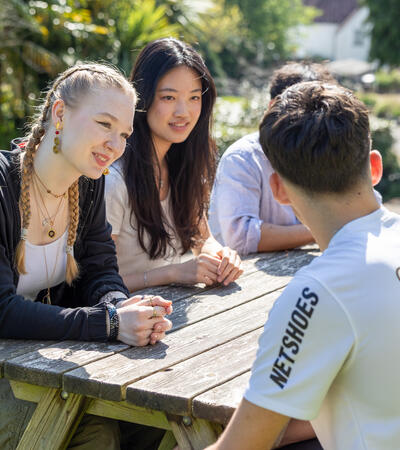 Sidcot international students chatting around table