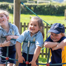 Sidcot Early Years pupils smiling on a climbing frame