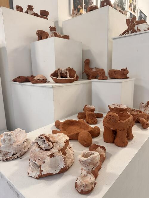 Clay animal figures on display shelving 